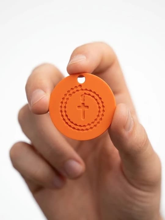 Tokillion naranja sujeto entre los dedos